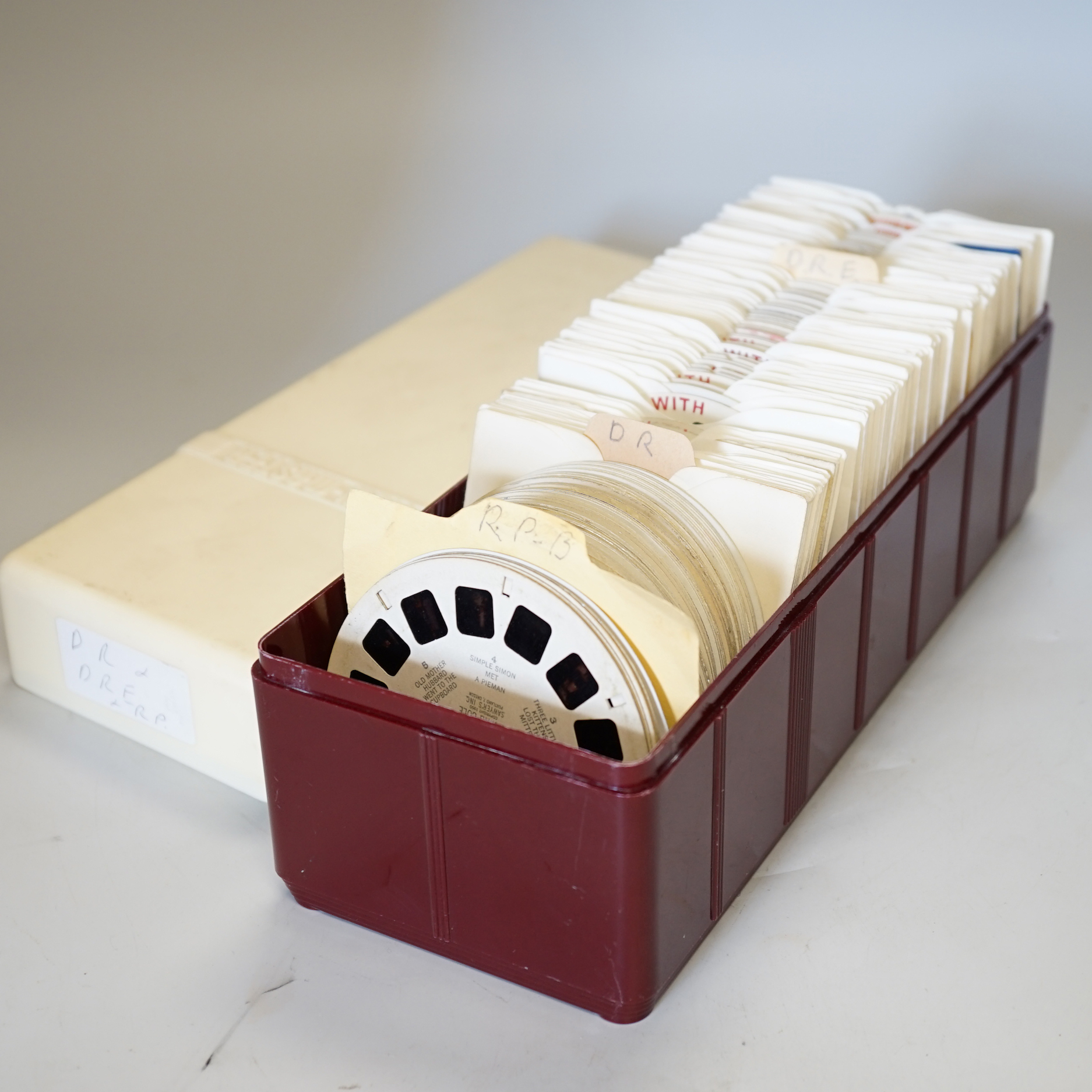 A large collection of View-Master reels contained within six plastic View-Master boxes, subjects include scenes from the United States, Charlie Brown, Bambi, Rin-Tin-Tin, etc.